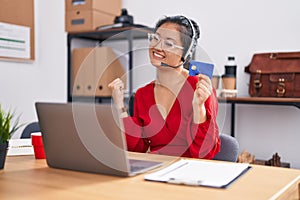 Asian young woman working using computer laptop and credit card screaming proud, celebrating victory and success very excited with