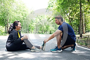 Asian young womanin sportwear is Cramping her leg and boyfriend helping for relaxation of resilient and Muscle contraction after