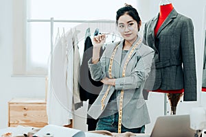 Asian young women fashion designer  working on her designer in the showroom,  Lifestyle Stylish tailor taking measurements on mann