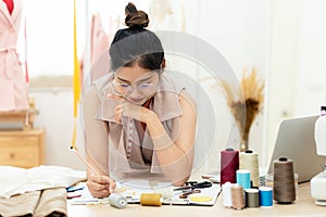 Asian young women fashion designer  working on her designer in the showroom,  Lifestyle Stylish tailor taking measurements on mann