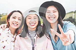 Asian young women friends having fun outdoor - Happy trendy girls laughing together - Millennial generation, bonding, friendship