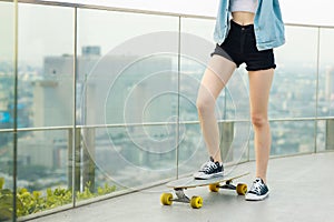 Asian young women surf skate or skates board outdoors on beautiful summer day. Happy young women happy play surf skate  at rooftop