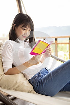 Asian younger woman ralaxing reading a book