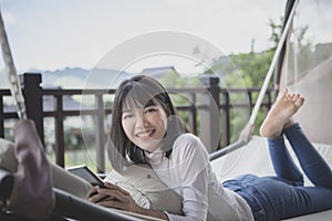 asian younger woman relaxing with toothy smiling face on a cradle