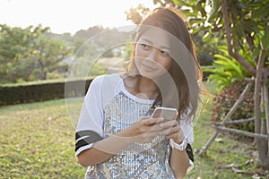 Asian younger woman with smartphone in hand happiness thinking ,