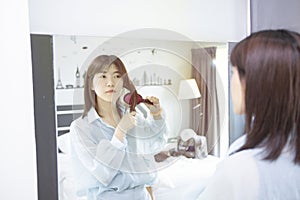 Asians girl is brushing her hair in front mirror at morning photo