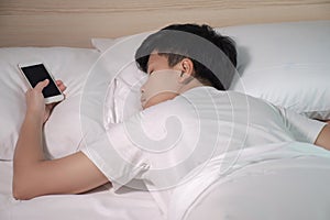 Asians sleep while the smartphone is on their hands photo