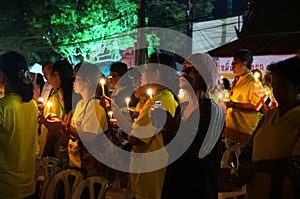 Asians stand with candles. Thais pray for the health of the king.