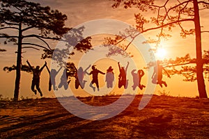 Asians traveler jumping in happy time at Phu Kradueng National Park at Sunset in Loei Province of thailand