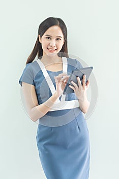 Asianwoman with a tablet computer. Asian business woman using digital tablet computer, leaning against a grey wall