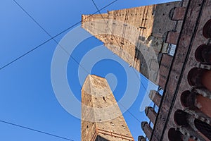 The Asinelli and Garisenda towers of Bologna ascend into the clear sky, a striking example of medieval Italian engineering