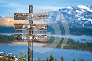 Ask believe recieve ext on wooden signpost outdoors in landscape scenery during blue hour.