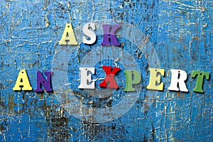 Ask an EXPERT concept. Wooden colorful abc letter on abstract blue grunge background.