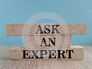 Ask an expert symbol. Concept words Ask an expert on brick blocks on a beautiful wooden table blue background. Business and ask an