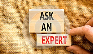 Ask an expert symbol. Concept words Ask an expert on wooden blocks on a beautiful canvas table canvas background. Businessman hand