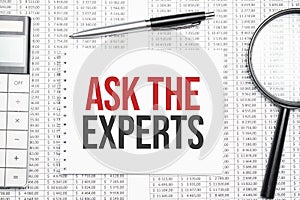 Ask the Expert text on paper with calculator,magnifier ,pen on the graph background