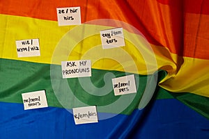 ASK MY PRONOUN Neo pronouns concept. Rainbow flag with paper notes text gender pronouns hie, e, ne, xe, ze, tey. Non