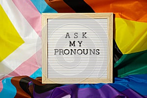 ASK MY PRONOUNS text Neo pronouns concept on Rainbow flag background gender pronouns. Non-binary people rights