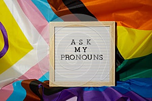 ASK MY PRONOUNS text Neo pronouns concept on Rainbow flag background gender pronouns. Non-binary people rights