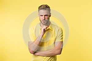 Asking himself. Handsome young man keeping hand on chin while stand yellow background. Existentialism concept. Hard
