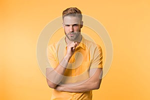 Asking himself. Handsome young man keeping hand on chin while stand yellow background. Existentialism concept. Hard