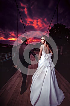 Askiz, Khakassia, Russia - August 17, 2013: Wedding, bride and groom go into bloody sunset.