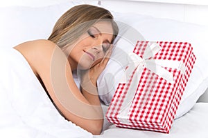 Asleep woman has surprise present waiting for her in bed.