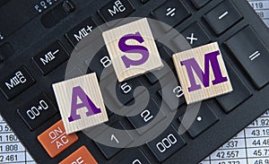 ASM - acronym on wooden cubes on the background of a calculator