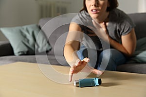 Asmathic girl catching inhaler having an asthma attack photo