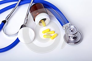 Asorted pils and a stethoscope on white background