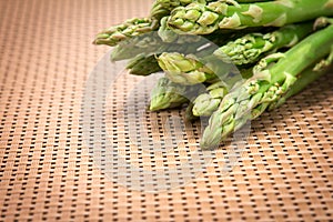 Asparagus bind with brown ribbon on brown wickerwork background