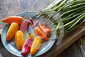 asparagus and bright colored peppers on a blue plate