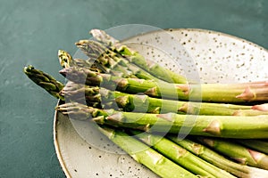 Asparagus close-up on a plate and green background