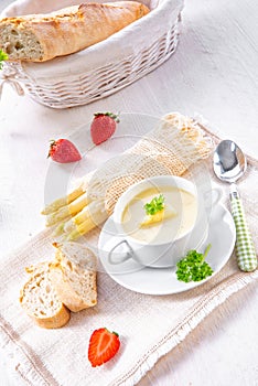 Asparagus cream soup with capers and fresh baguette