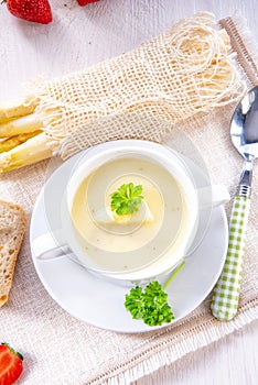 Asparagus cream soup with capers and fresh baguette