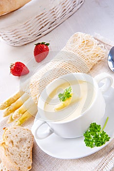 Asparagus cream soup with capers and fresh baguette photo