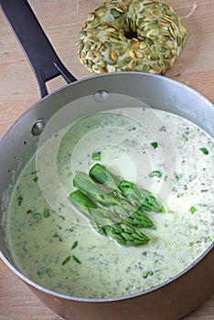 Asparagus cream soup in a copper casserole