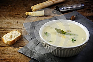 Asparagus cream soup with parsley garnish in a bowl, nutmeg grat