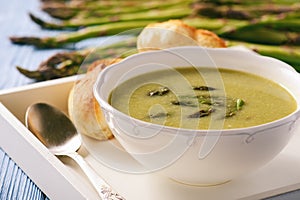 Asparagus cream soup on wooden tray.
