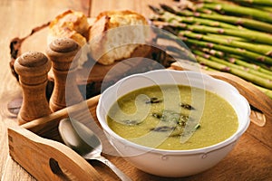 Asparagus cream soup on wooden tray.