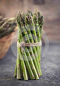 Asparagus. Fresh raw organic green Asparagus sprouts closeup. Over wooden table. Healthy vegetarian food. Raw vegetables