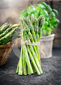 Asparagus. Fresh raw organic green Asparagus sprouts closeup. Over wooden table. Healthy vegetarian food. Raw vegetables, market