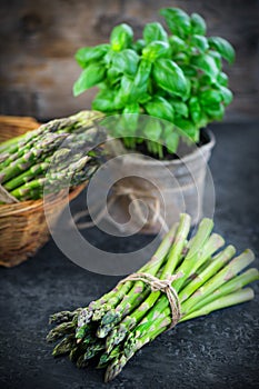 Asparagus. Fresh raw organic green Asparagus sprouts closeup. Over wooden table. Healthy vegetarian food. Raw vegetables, market