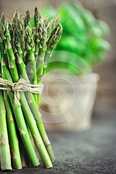 Asparagus. Fresh raw organic green Asparagus sprouts closeup. Over wooden table. Healthy vegetarian food. Raw vegetables, market