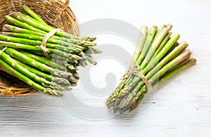 Asparagus. Fresh raw organic green Asparagus sprouts closeup. On white wood table background. Healthy vegetarian food