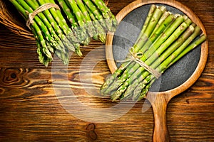 Asparagus. Fresh raw organic green Asparagus sprouts closeup. On wooden table background. Healthy vegetarian food