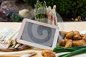 Asparagus, potatoes, empty blackboard