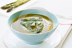 Asparagus soup in a bowl with fresh cream and dill