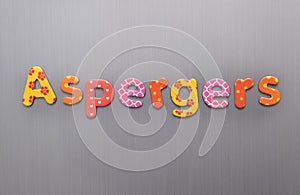Aspergers word spelled out in bright colorful patterened letters on brushed metal background photo