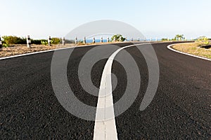 Asphalt coastal road going round cliff edge bend.